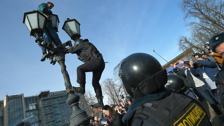 Одними из главных героев акции на Пушкинской площади стали два подростка, забравшихся на фонарь. Сотрудники полиции так и не смогли их оттуда снять и задержали, только когда ребята спустились сами, фото: Александр Миридонов / Коммерсантъ